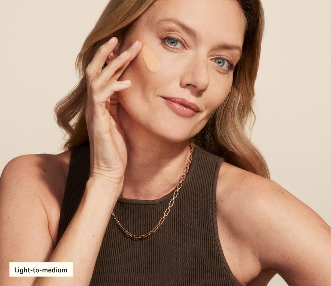 Woman applying SilkScreen to face (light-to-medium)