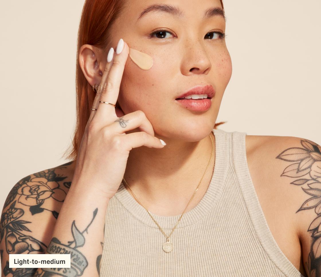 Woman applying SilkScreen to face (light-to-medium)